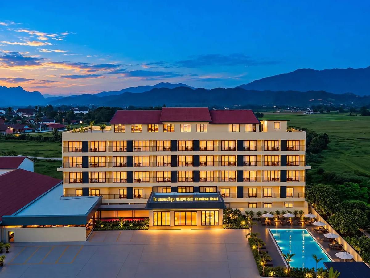 Vangvieng Thavikun Hotel lit up at dusk